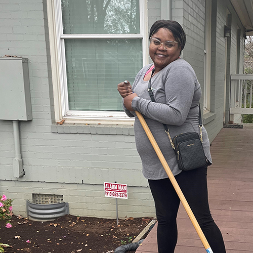 women holding a broom in a driveway